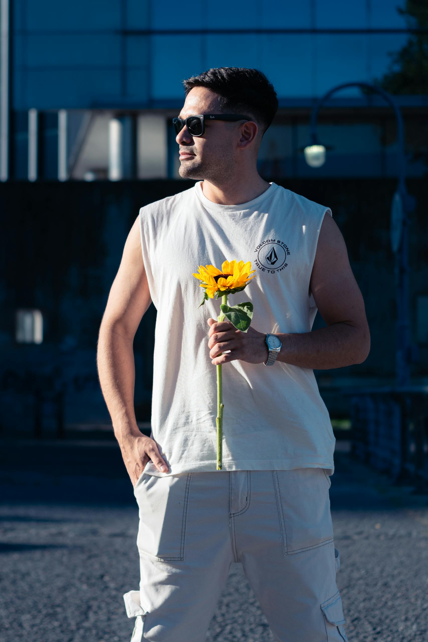 Creating A Masculine Demo Page A stylish man in sunglasses holds a sunflower on a sunny Buenos Aires street.