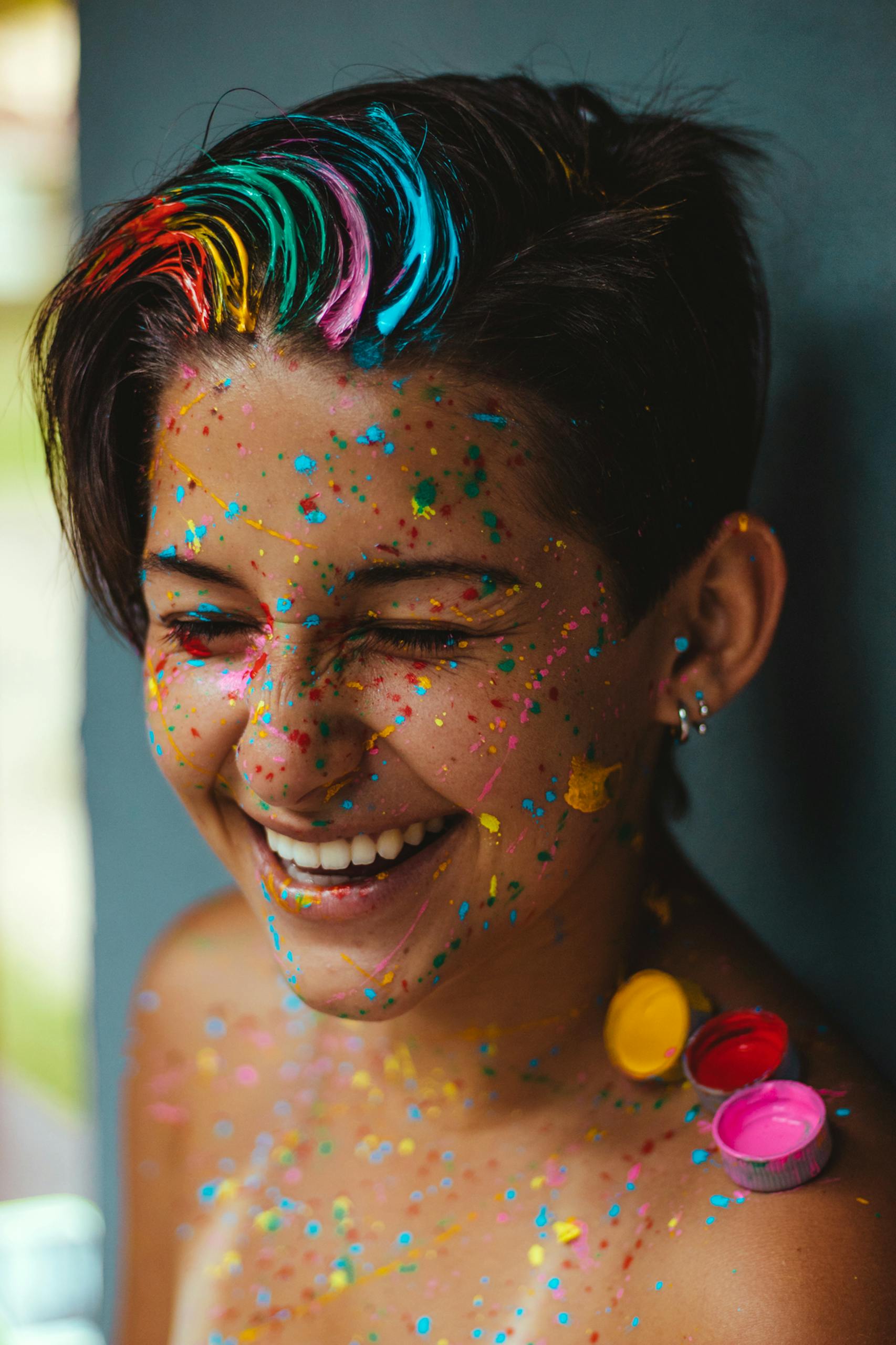 Understanding Feminine WordPress Themes Feminine WordPress Themes with a Smiling woman with vibrant face paint and colorful confetti, celebrating happiness and creativity.