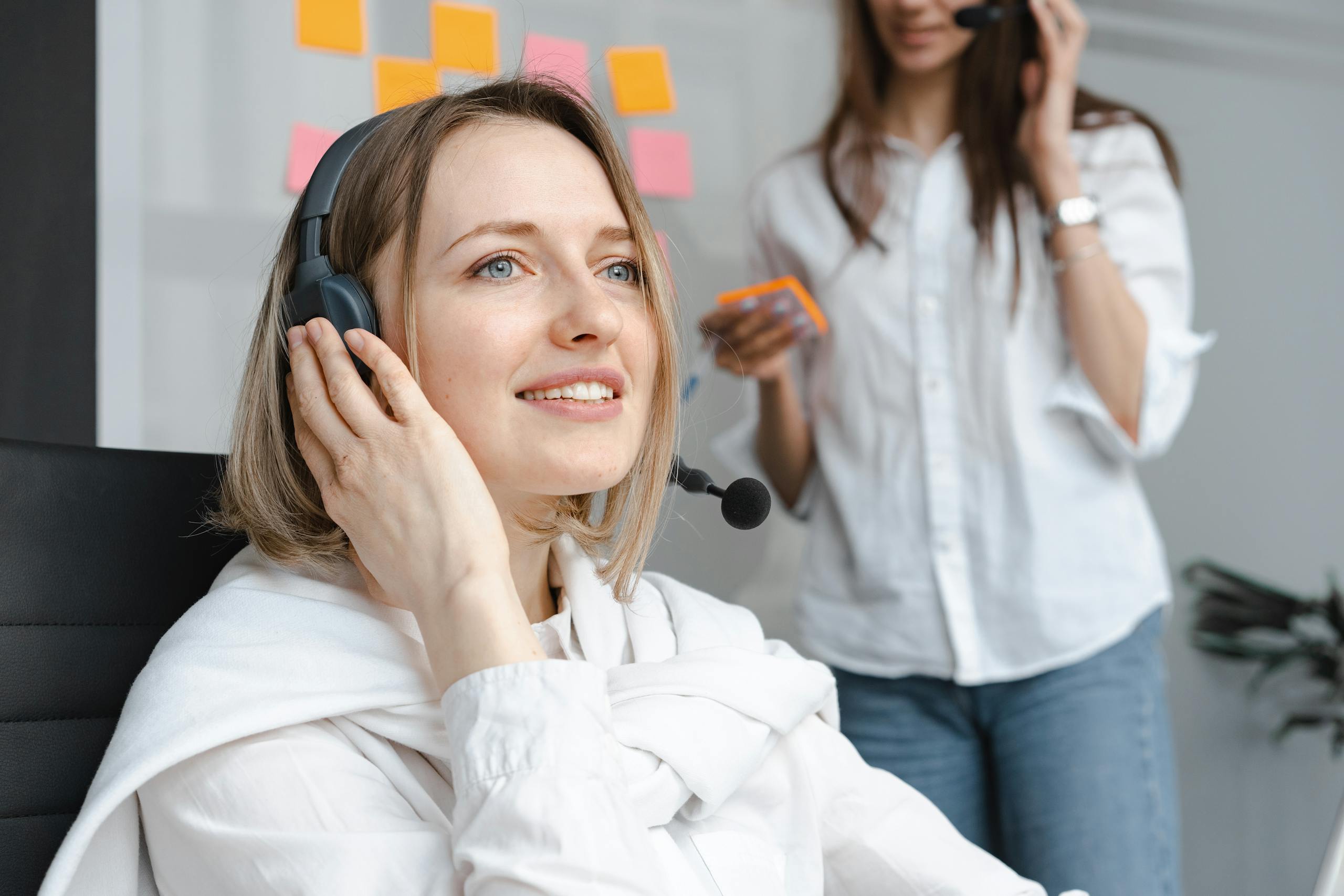 ScalaHosting Support That Treats You Like a Human Smiling customer support agent wearing a headset providing efficient service.